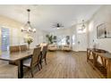 Bright living area featuring hardwood floors, plantation shutters, a dining area and neutral decor at 7908 W Harmony Ln, Peoria, AZ 85382
