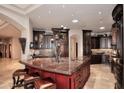 Gourmet kitchen with custom dark wood cabinets and a large center island with seating at 8406 E Calle Buena Vis, Scottsdale, AZ 85255