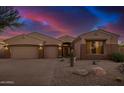 Charming desert home featuring a three-car garage and manicured gravel landscaping at 9604 S 183Rd Dr, Goodyear, AZ 85338