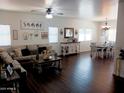 Open-concept living room with hardwood floors, a ceiling fan, and white walls at 11219 N 165Th Ave, Surprise, AZ 85388