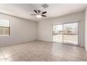 Bright, airy bedroom with tile flooring, ceiling fan, and sliding glass door access to the backyard at 1178 E Tyler Ln, Casa Grande, AZ 85122