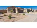 Attractive single-story home with desert landscaping, a spacious driveway, and a two-car garage at 1178 E Tyler Ln, Casa Grande, AZ 85122