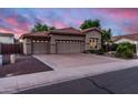 Charming home featuring a three-car garage and tidy front yard, all beneath a colorful evening sky at 1528 E Harrison St, Gilbert, AZ 85295