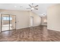 Open living room with tile flooring, a ceiling fan, and sliding glass doors to the backyard at 16508 N 114Th Dr, Surprise, AZ 85378