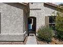 Close up of home's stucco exterior and arched entryway with view of the front door at 19372 E Timberline Rd, Queen Creek, AZ 85142