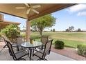 Charming covered back porch with seating, offering a relaxing view of the golf course and clear blue skies at 24511 S Golfview Dr, Sun Lakes, AZ 85248