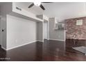 Open-concept living area features hardwood floors and decorative brick, blending modern design and warmth at 3302 N 7Th St # 108, Phoenix, AZ 85014