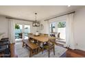 Bright dining room with wood table, bench seating, and french doors leading to patio and pool at 3514 N 83Rd St, Scottsdale, AZ 85251