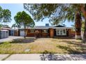 Charming brick home with well-maintained landscaping, a garage, and mature trees under a clear, sunny sky at 3514 N 83Rd St, Scottsdale, AZ 85251