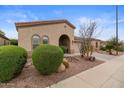 Inviting home exterior with landscaped front yard featuring desert accents and an attached two-car garage at 4515 E Rakestraw Ln, Gilbert, AZ 85298