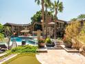 Luxury backyard featuring a pool with water features, outdoor seating, and a manicured lawn at 5040 N Arcadia Dr, Phoenix, AZ 85018