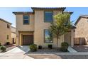 View of a two-story tan home with a brown garage door and desert landscaping at 5233 W Albeniz Pl, Phoenix, AZ 85043