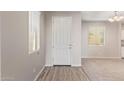 Bright entryway with wood-look flooring transitioning to plush carpeting and a white front door at 5472 W Fulton St, Phoenix, AZ 85043