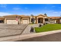 Elegant single-story home featuring a three-car garage, well-manicured lawn, and inviting entryway, offering comfort and style at 5670 W Linda Ln, Chandler, AZ 85226