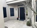 Inviting courtyard entry with a black door, potted plants, and stone pavers at 6181 E Brilliant Sky Dr, Scottsdale, AZ 85266
