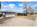 Well-kept house featuring an attached garage, a lengthy driveway, and neatly trimmed landscaping at 6938 E Flossmoor Ave, Mesa, AZ 85208