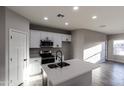 Well-lit kitchen featuring white cabinets, stainless steel appliances, and a central island with a sink at 8315 W Concordia Dr, Arizona City, AZ 85123