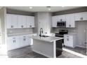 Bright kitchen boasts white shaker cabinets, modern appliances, ample counter space and an island with bar seating at 8315 W Concordia Dr, Arizona City, AZ 85123