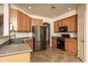 Well-lit kitchen includes stainless steel appliances, wood cabinets, and tile flooring at 8339 W Molly Ln, Peoria, AZ 85383