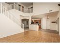 Bright living room featuring a staircase, high ceilings, hardwood floors, and access to the kitchen at 8339 W Molly Ln, Peoria, AZ 85383