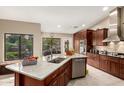 This spacious kitchen features custom cabinets, granite countertops, stainless steel appliances, and island with breakfast bar at 8861 E Sutton Dr, Scottsdale, AZ 85260