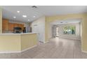 Open kitchen with stainless steel appliances, breakfast bar, and tile flooring throughout at 10817 W Wilshire Dr, Avondale, AZ 85392