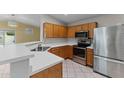 Bright kitchen with stainless steel appliances, wood cabinets, and a breakfast bar at 10817 W Wilshire Dr, Avondale, AZ 85392