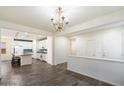 Bright, open-concept room with wood-look tile flooring adjacent to modern kitchen at 12114 W Desert Moon Way, Peoria, AZ 85383