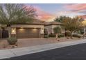 Single-story home with desert landscaping, a two-car garage, and a charming front entrance at 18491 N 98Th Way, Scottsdale, AZ 85255