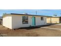 Rear view of updated home, showcasing fresh paint, tidy landscaping and attractive turquoise door at 1851 E Pleasant Ln, Phoenix, AZ 85042