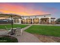 Spacious backyard with covered patio, outdoor seating, and lush green lawn at 19717 E Country Meadows Dr, Queen Creek, AZ 85142