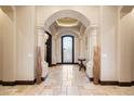 Grand foyer with travertine floors, arched doorways, and decorative niches at 19717 E Country Meadows Dr, Queen Creek, AZ 85142