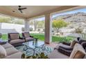 Cozy covered patio featuring comfortable seating and a beautiful view of the lush backyard at 2008 E Rock Wren Rd, Phoenix, AZ 85048