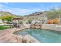 Inviting backyard pool with rock waterfall feature and ample space for outdoor seating at 2008 E Rock Wren Rd, Phoenix, AZ 85048