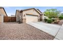 A view of the home's exterior, featuring a two-car garage and low-maintenance desert landscaping at 2336 W Magdalena Ln, Phoenix, AZ 85041