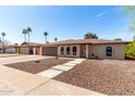 Charming single-story home featuring a brick facade, arched windows, a well-maintained yard, and long driveway at 2416 S Evergreen Rd, Tempe, AZ 85282