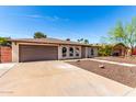 Charming single-story home featuring a brick facade, arched windows, and a well-maintained driveway at 2416 S Evergreen Rd, Tempe, AZ 85282
