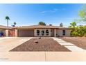 Charming single-story home featuring a brick facade, arched windows, and a well-maintained front yard at 2416 S Evergreen Rd, Tempe, AZ 85282