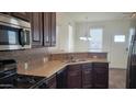 Well-lit kitchen featuring stainless steel appliances and a cozy breakfast bar area at 2460 E Main St # F7, Mesa, AZ 85213