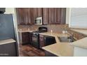 Modern kitchen with stainless steel appliances, rich wood cabinets, and light countertops at 2460 E Main St # F7, Mesa, AZ 85213