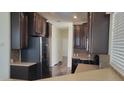 Spacious kitchen featuring dark wood cabinets, stainless appliances, and hardwood floors at 2460 E Main St # F7, Mesa, AZ 85213