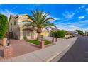 Two-story home with a lush palm tree, a brick walkway entrance, and a two car attached garage at 25425 N 64Th Ave, Phoenix, AZ 85083