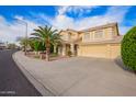 Inviting two-story home with a lush palm tree, well-maintained lawn, and a brick paver walkway at 25425 N 64Th Ave, Phoenix, AZ 85083