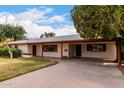 Charming single-story home featuring mature landscaping, a covered carport, and a lengthy driveway at 4249 E Mitchell Dr, Phoenix, AZ 85018