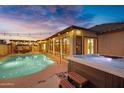 Backyard oasis featuring a pool and a hot tub, perfect for outdoor entertaining under string lights at 5431 W Cochise Dr, Glendale, AZ 85302