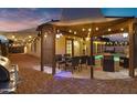 Backyard with covered patio, dining table, barbecue, string lights, and pavers, ideal for gatherings at 5431 W Cochise Dr, Glendale, AZ 85302