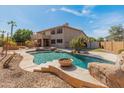 Inviting backyard oasis with a custom pool, spa, rock features, mature palms and desert landscaping at 5917 N 133Rd Ave, Litchfield Park, AZ 85340