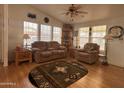 Cozy living room with a ceiling fan, matching sofa and chair, and a rug with southwest patterns at 650 N Hawes Rd # 4609, Mesa, AZ 85207