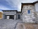 Beautiful stone and stucco home with a paved driveway and a two-car garage at 6790 S Springs Pl, Chandler, AZ 85249
