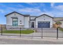 Beautiful modern elevation featuring a black iron fence, well kept lawn, and a two car garage at 6790 S Springs Pl, Chandler, AZ 85249